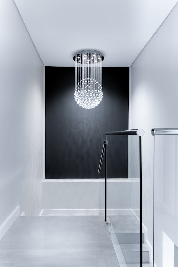 our-story Sleek contemporary hallway featuring a stunning glass chandelier and minimalist design.